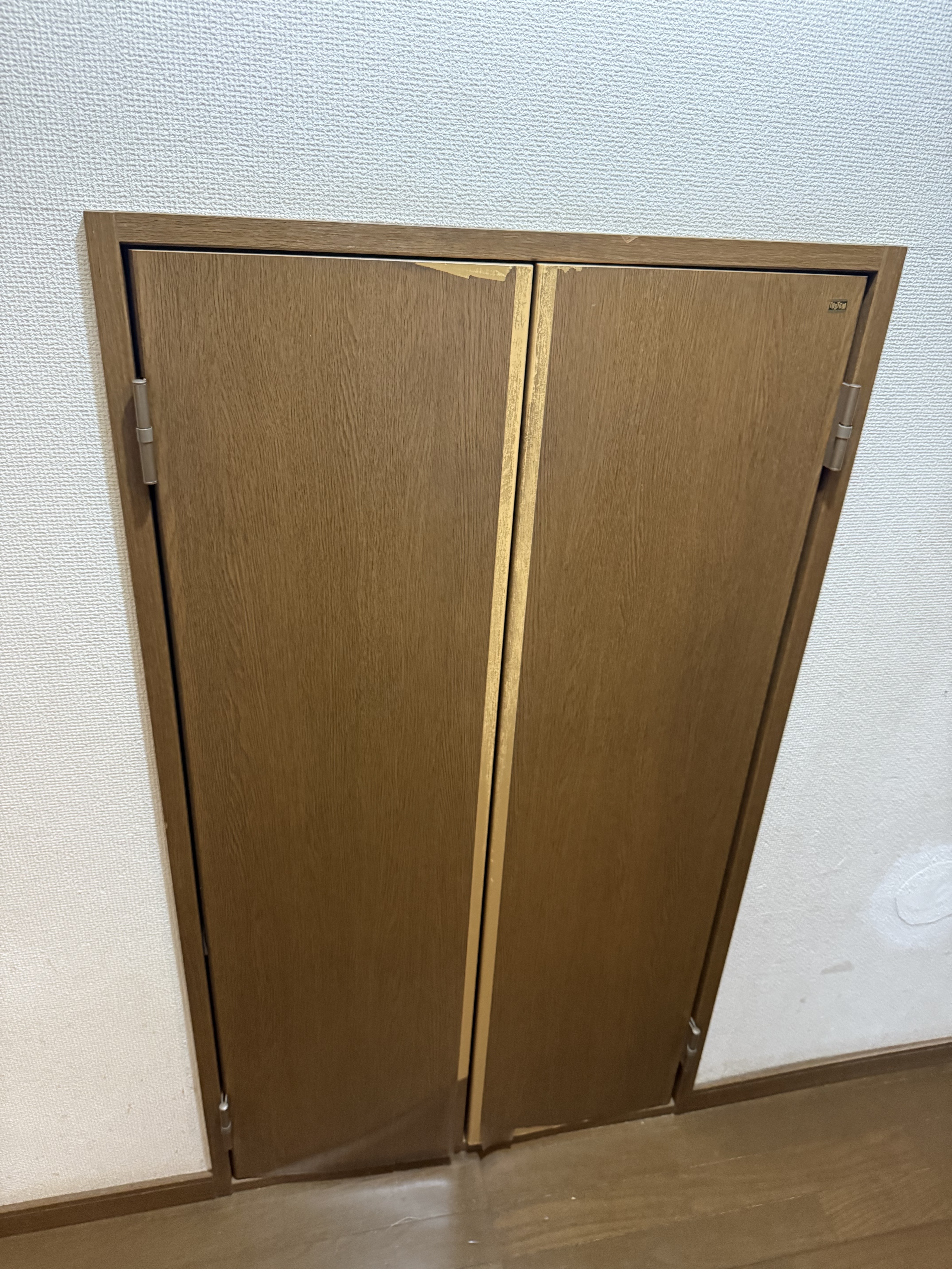 階段下物置ドア交換前。建付けのズレや劣化が進行