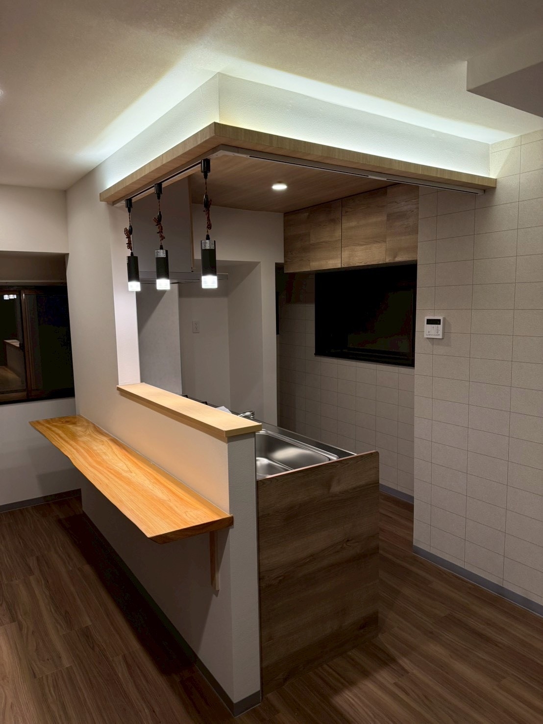 キッチン腰壁造作工事の施工後。間仕切りとカウンター、照明でおしゃれで使いやすい空間に